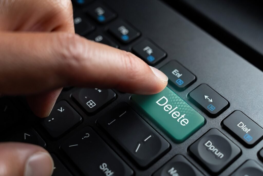 A photograph of a hand pressing a stylized delete or backspace key on a modern keyboard, with a very subtle green glow on the 'Delete' key, resume skills to delete