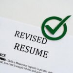 a white paper showing tick checkmark against words revised resume, resume skills