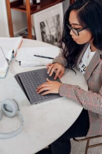 Photo by Surface woman in red and white plaid long sleeve shirt using platinum coloured microsoft surface laptop computer, career hub